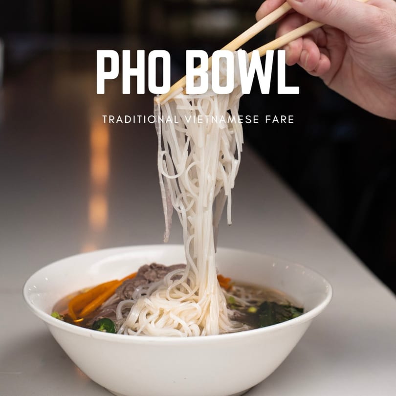 Chopsticks lifting pho noodles from a white bowl of Pho Bowl's traditional Vietnamese fare.